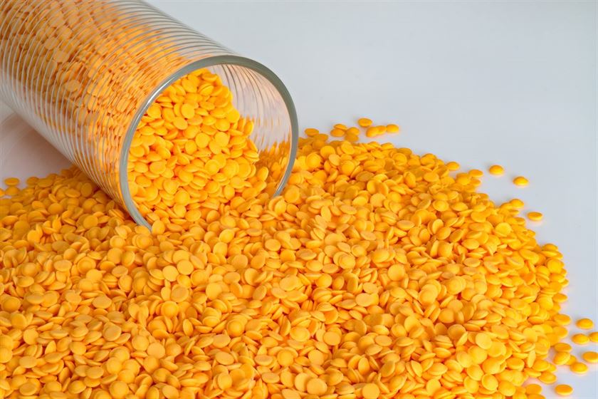 materiales reciclados Polypropylene beads, plastic orange pellets on white color background.